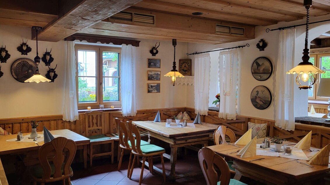 Ein gemütliches Restaurant mit Holztischen und -stühlen. Die Wände sind mit Bildern und Dekorationen geschmückt, und das Licht ist warm und einladend. | ©  Petra Kirchschlager