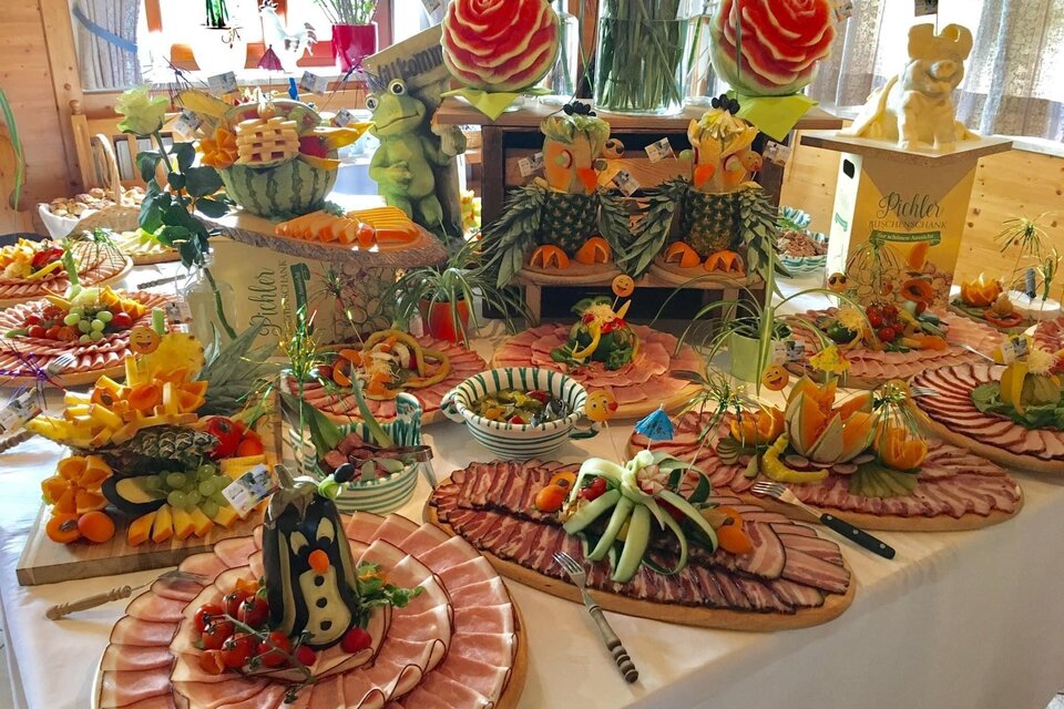Ein wunderschöner Tisch mit kunstvoll arrangierten Obst- und Gemüseplatten sowie Fleischspezialitäten. Verschiedene Farben und Formen verleihen dem Buffet ein festliches Aussehen. | © Maluhof Markus Lugitsch