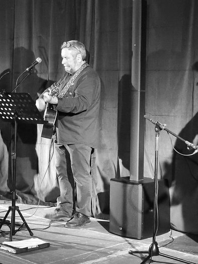 Three musicians are on a stage playing live music. One plays the violin while the others play guitar and sing. | © Stadtgemeinde Trofaiach