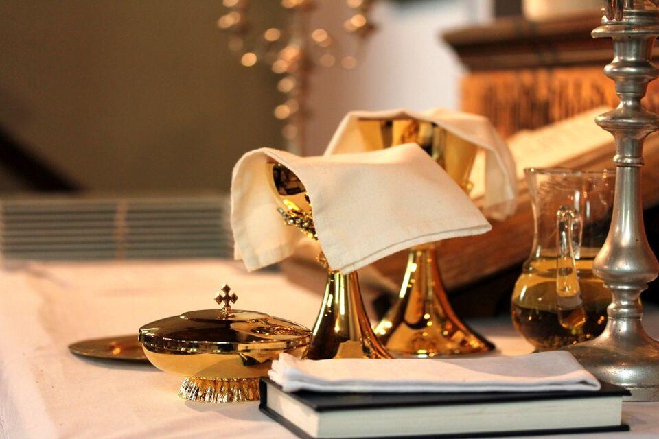 Ein Tisch mit goldenem Geschirr, einer Kanne und einem Buch. Darauf liegen Servietten und Dekorationselemente. | © Tieber Doris