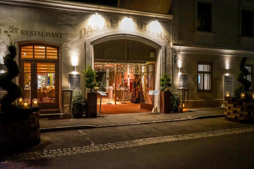Ein einladender Restaurant-Eingang mit warmem Licht und festlicher Dekoration. Umgeben von Pflanzen und gemütlicher Atmosphäre. | © Hotel Fontana