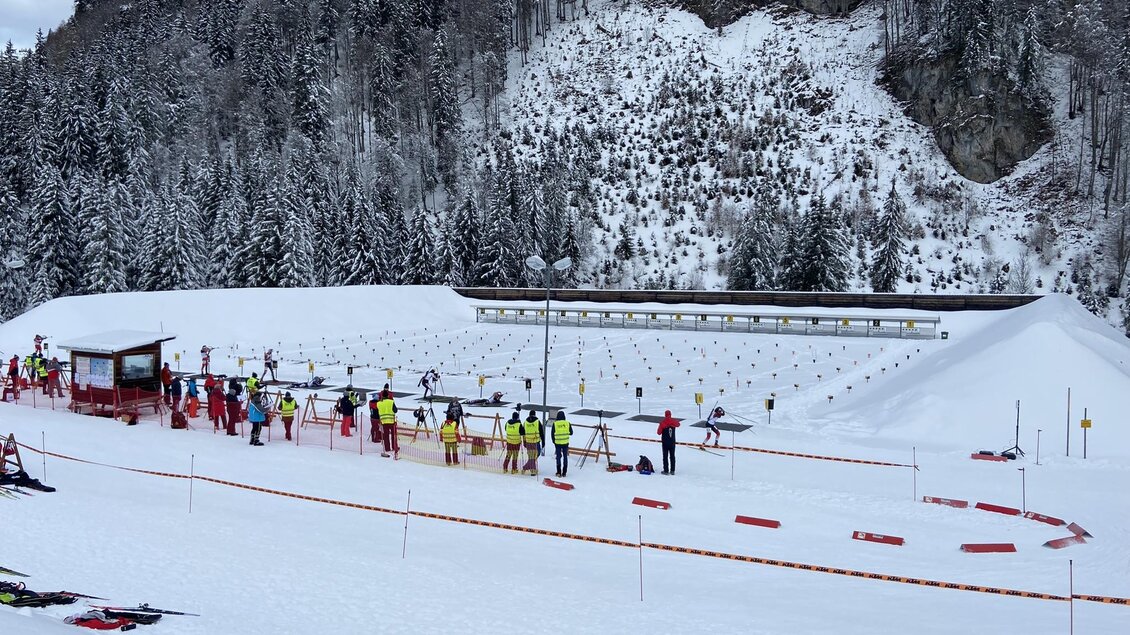 Eine verschneite Landschaft mit Skifahrern und einer Biathlonbahn. Umgeben von hohen Bäumen und Bergen. | © NAZ Eisenerz