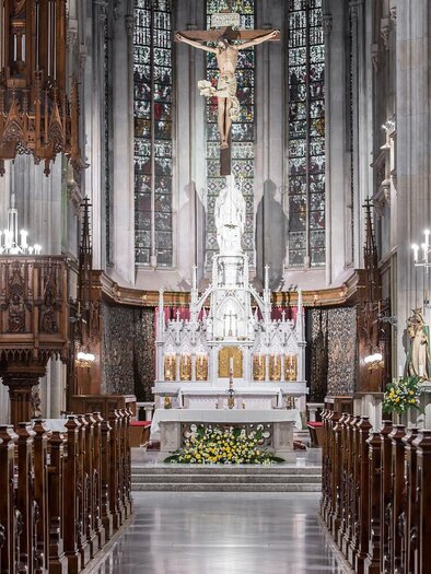 Eine wunderschöne Kirche mit einem Altar und einer Statue von Jesus. Das Innere ist reich verziert mit Holzarbeiten und Kronleuchtern.