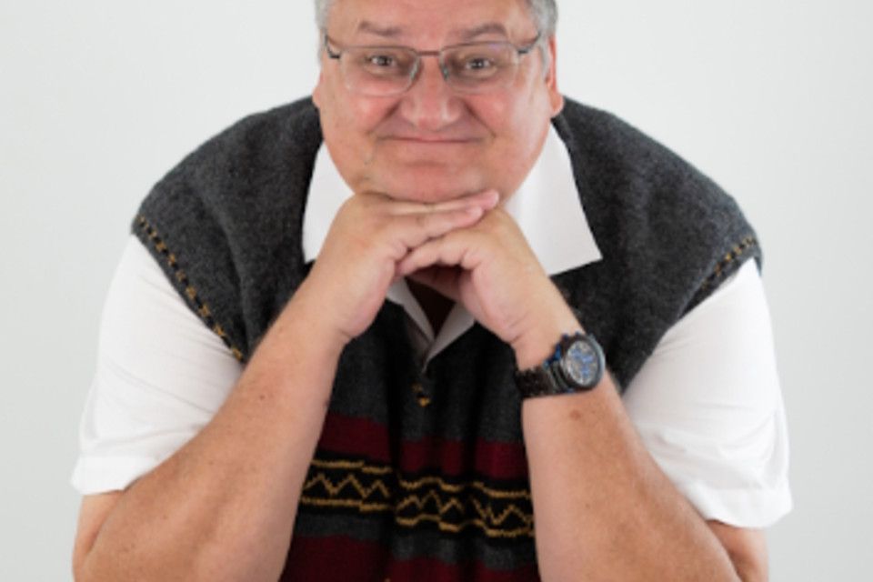 Ein farbenfrohes Plakat von Kammerhofer mit einem lächelnden Mann in einem bunten Pullover. Der Text enthält verschiedene Veranstaltungshinweise und den Titel "Amois Ois". | © Walter Kammerhofer