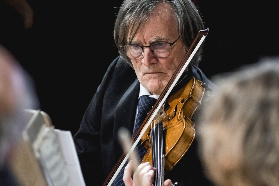 Ein älterer Mann spielt Violine auf einer Bühne. Er trägt einen Anzug und konzentriert sich auf die Musik. | © Ernst Friessnegg