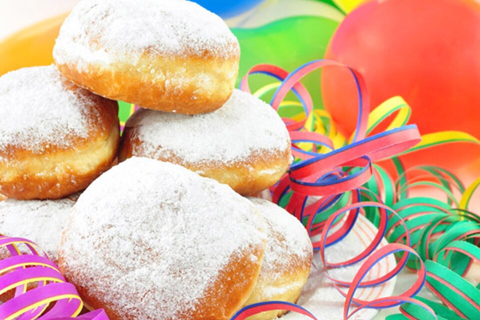 Eine Auswahl von zuckersüßen Berliner, die auf einem bunten Tisch liegen. Umgeben von Festdekoration und Luftballons. | © Fotolia