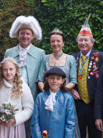A festive group of people in traditional clothing stands together. They are smiling and wearing medals as well as colorful hats. | © KFG-Robert Salmhofer