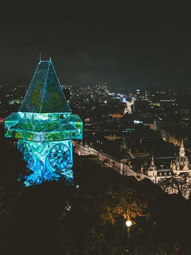 A lit tower stands over the city at night. In the background, the lights of the city can be seen. | © © Luke_Goodlife for Klanglicht