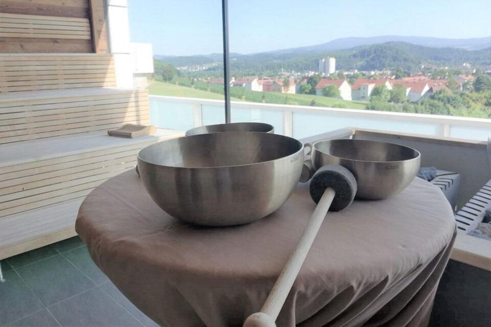 Drei große Metall-Schalen stehen auf einem Tisch mit Blick auf eine grüne Landschaft. Im Hintergrund sind Häuser und Berge zu sehen. | © Die Abbilderei