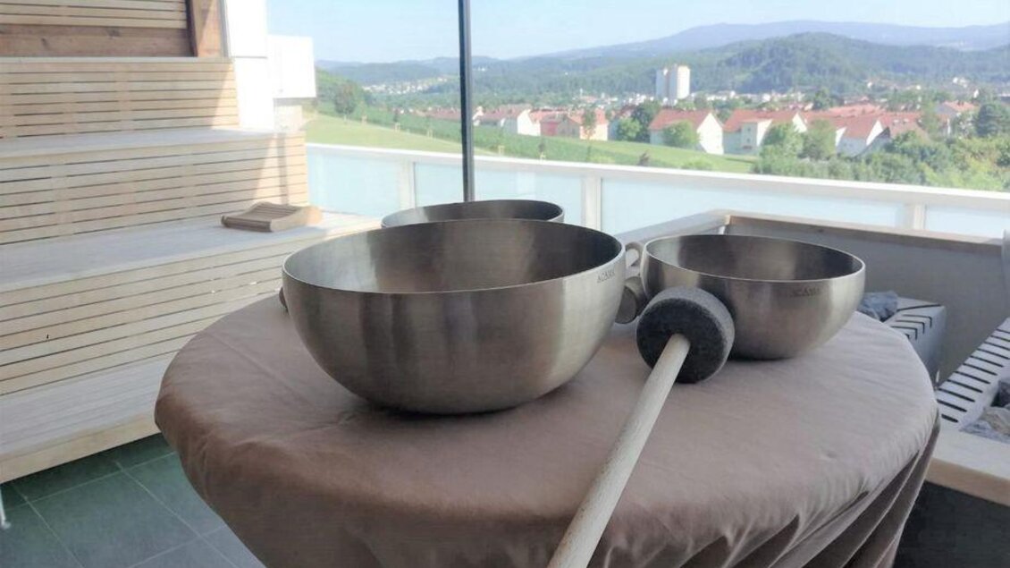 Drei große Metall-Schalen stehen auf einem Tisch mit Blick auf eine grüne Landschaft. Im Hintergrund sind Häuser und Berge zu sehen. | © Die Abbilderei