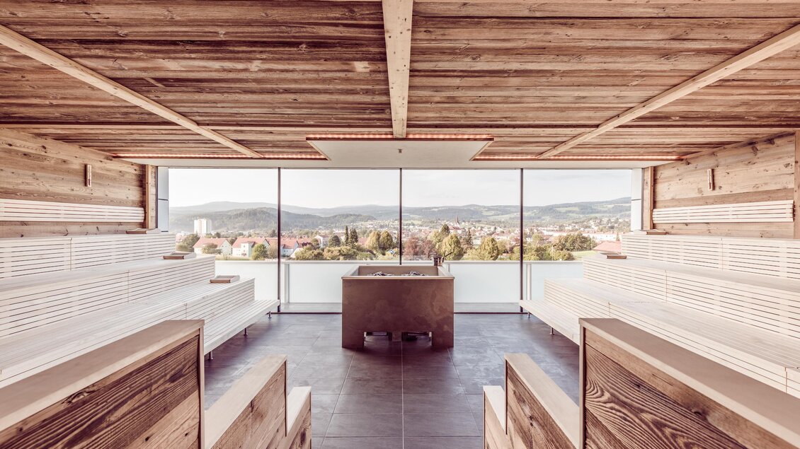 Ein moderner Raum mit Holzdetails und großen Fenstern. Er bietet einen Blick auf die Landschaft und das Wasser. | © Lipizzanerheimat-DieAbbilderei