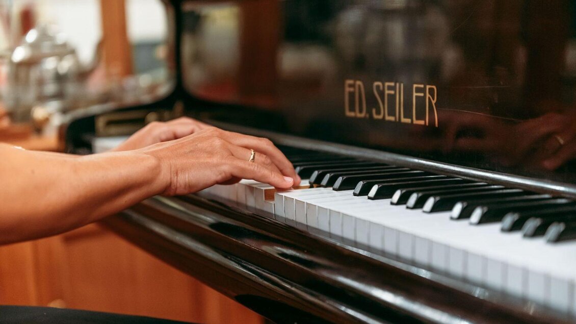 Ein Pianist spielt auf einem schwarzen Klavier mit der Aufschrift „ED. SEILER“. Die Hände sind elegant über die Tasten platziert. | © Karl Steinegge