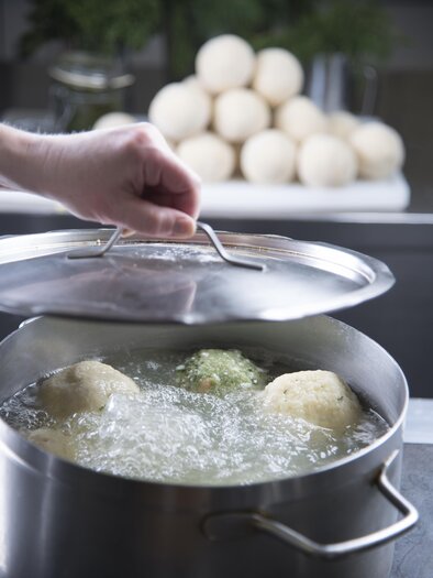 Egy fazék forrásban lévő vízzel és több gombóccal készül. A háttérben egy gombóc csoport látható. | © Bernhard Bergmann