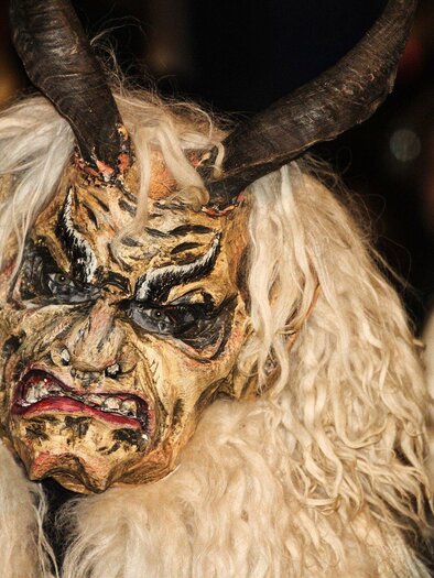 A person is wearing an impressive mask with horns and long, white hair. The mask has a menacing face with expressive features. | © Pixabay