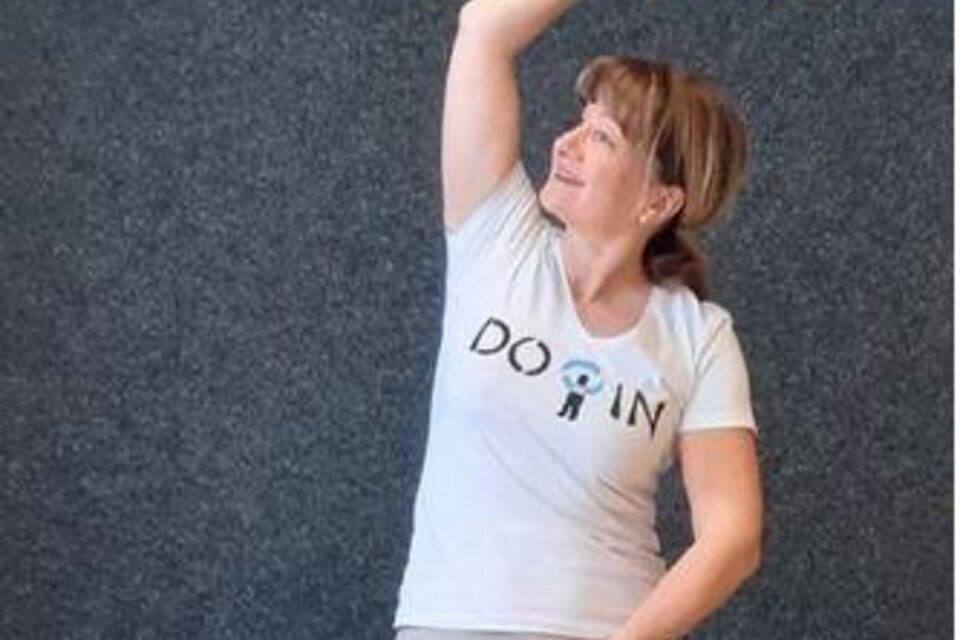 Eine Frau in einem sportlichen T-Shirt streckt ihren Arm in die Höhe. Sie hat ein freundliches Lächeln und scheint aktiv zu sein. | © Petra Cibulak