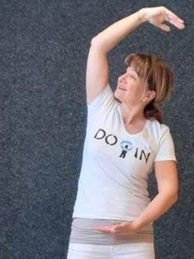 Eine Frau in einem sportlichen T-Shirt streckt ihren Arm in die Höhe. Sie hat ein freundliches Lächeln und scheint aktiv zu sein. | © Petra Cibulak