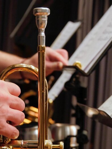 A musician plays the trumpet while sheet music is ready on a stand. The atmosphere feels focused and musical. | © Pixabay