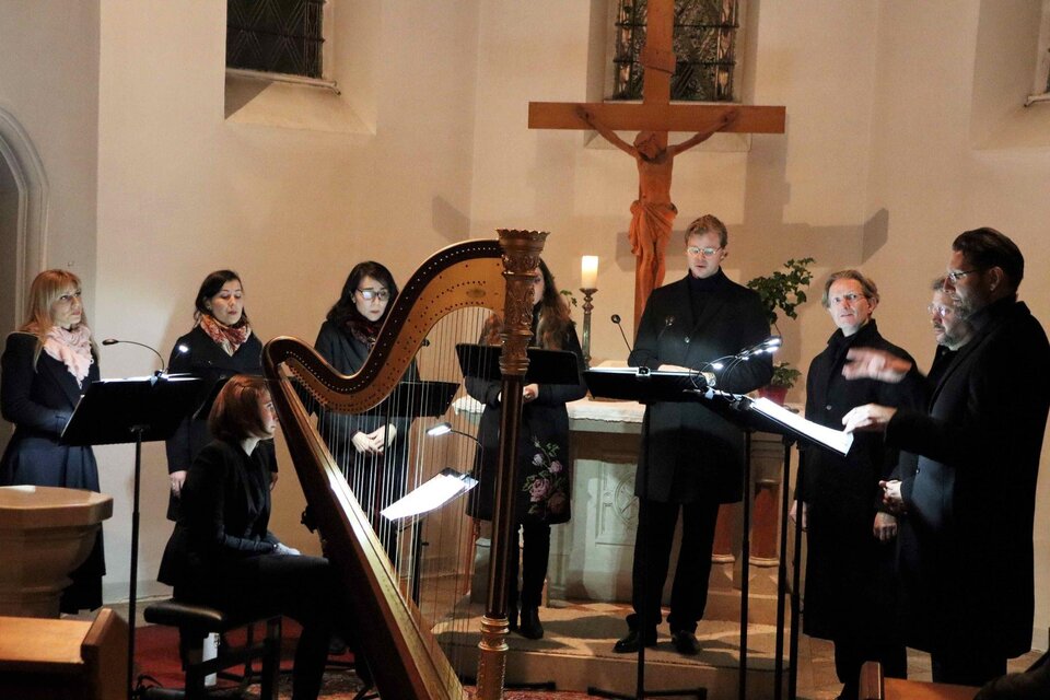 Eine Gruppe von Sängern steht in einer Kirche und singt. Im Vordergrund befindet sich eine Harfe. | © StainZeit - Gerhard Langmann