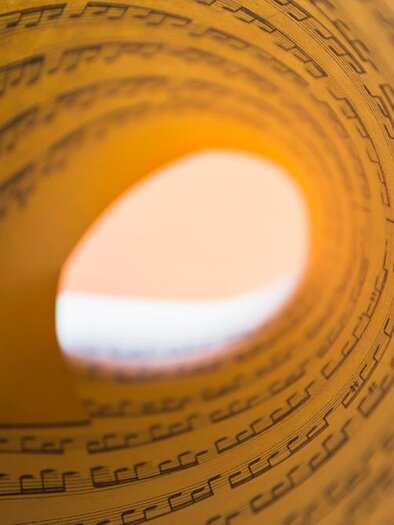 Ein eindrucksvolles Bild von einer gerollten Notenblatt. Die Musiknoten sind klar sichtbar und verleihen dem Bild eine künstlerische Note. | ©  Freepik