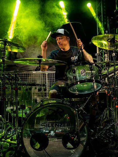 A drummer plays passionately on his drum. Bright light and fog create an energetic atmosphere. | ©  Silenzer