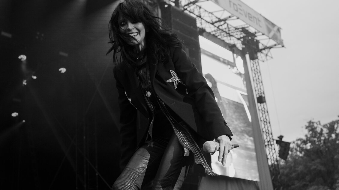 Sängerin Nena bei einem Live-Auftritt im Lipizzanergestüt Piber, lachend mit Mikrofon auf der Bühne. | © Sarah_Rechbauer _ Laugh + Peas Entertainment + Lifestyle GmbH