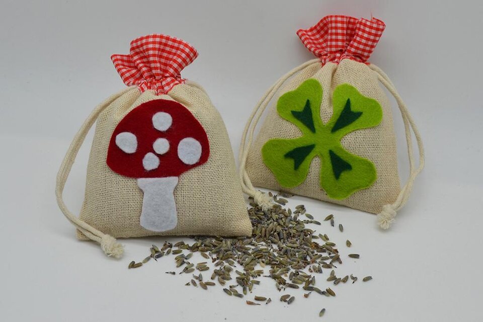 Zwei kleine säckchen aus Stoff mit verschiedenen Motiven. Eines zeigt einen Pilz und das andere ein Kleeblatt, umgeben von getrocknetem Lavendel. | © KulturQuartier