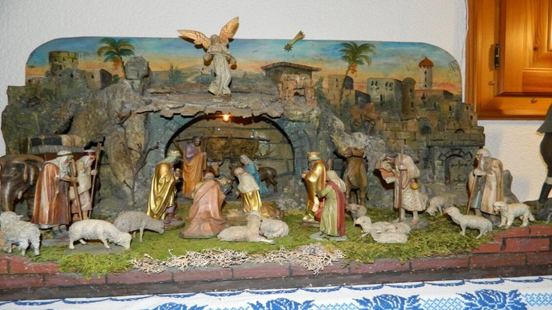 Eine Weihnachtskrippe mit Figuren, die die Geburt Jesu darstellen. Im Hintergrund sind eine Höhle und eine Landschaft zu sehen. | © Birgit Schretthauser