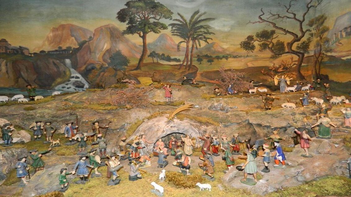 Eine farbenfrohe Landschaft mit vielen Figuren, die verschiedene Aktivitäten aus dem ländlichen Leben darstellen. Im Hintergrund sind Berge und Palmen zu sehen. | © Birgit Schretthauser