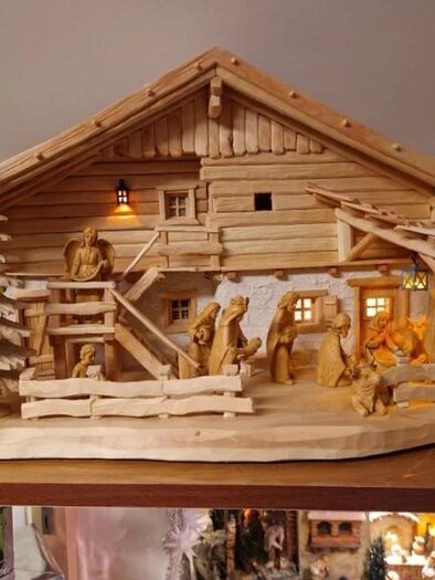 A decorative wooden figure of a rural building with figures and trees. The model depicts a lovingly designed scene in alpine style. | © Adi Barazutti