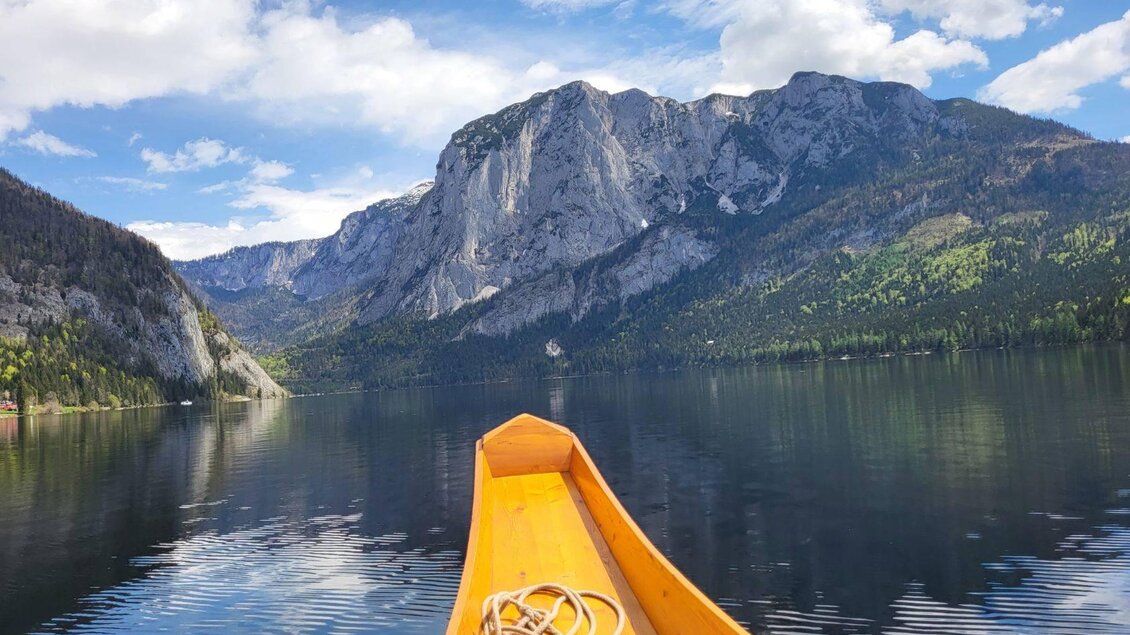 Eine ruhige Seenlandschaft mit einem Kanu im Vordergrund. Majestätische Berge und ein klarer Himmel umgeben das Wasser. | © TVB Ausseerland Petra Kirchschlager