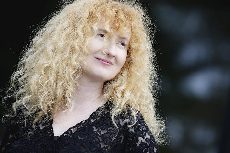 Eine Frau mit lockigem, blonden Haar lächelt freundlich. Sie trägt ein schwarzes Oberteil und scheint entspannt zu sein. | ©  Kanizaj Marija