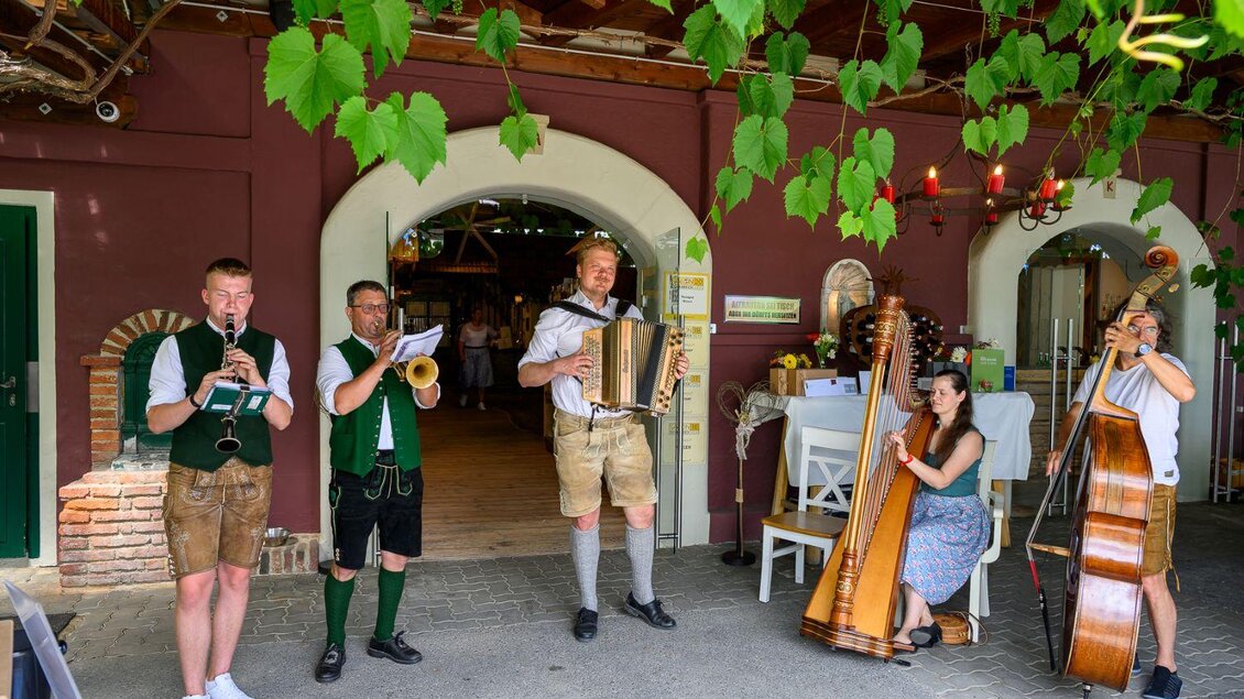 Eine Gruppe von Musikern spielt traditionelle Instrumente vor einem Gebäude. Die Atmosphäre ist festlich und einladend. | © ©pixelmaker