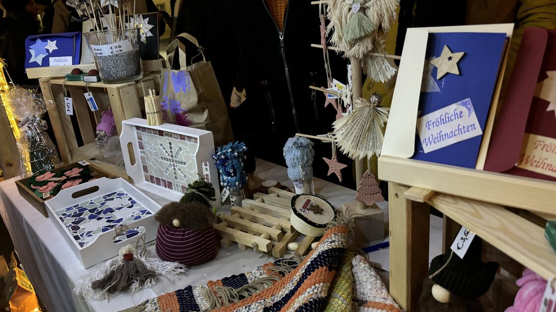 Ein Marktstand mit handgemachten Produkten wie Sternen, Karten und Wollmützen. Bunte Dekorationen und Geschenke sind sichtbar. | © Oststeiermark Tourismus