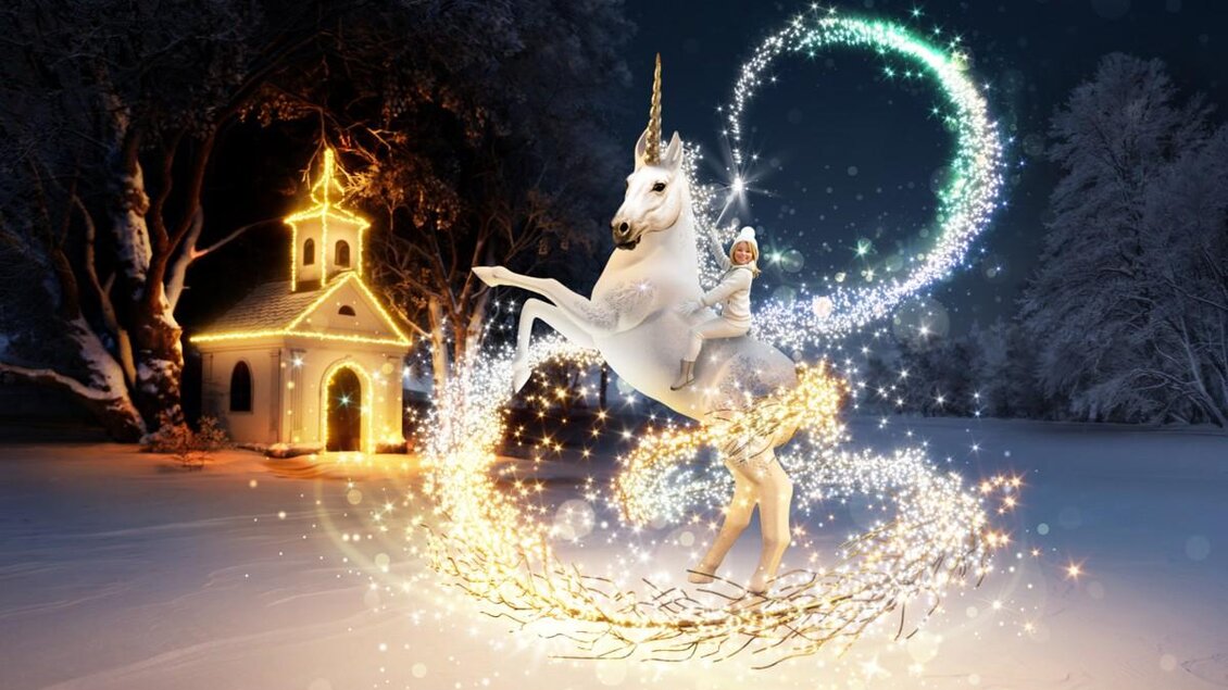 Ein zauberhaftes Einhorn mit einem Mädchen, das in einem verschneiten Winterwald tanzt. Im Hintergrund steht eine beleuchtete Kapelle.