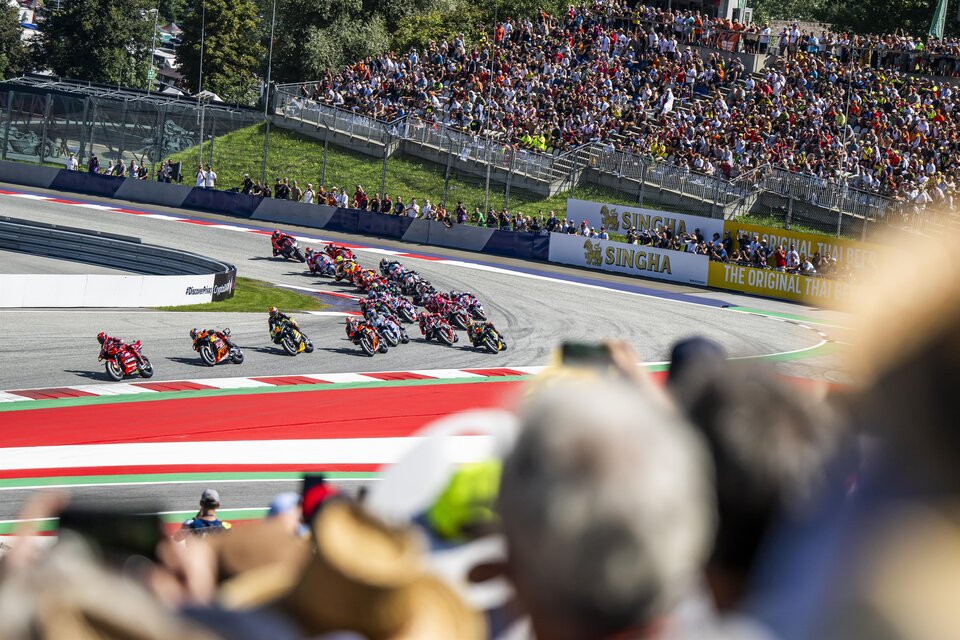 Ein spannendes Motorradrennen auf einer Rennstrecke mit jubelnden Zuschauern. Die Fahrer fahren in einer Kurve mit hoher Geschwindigkeit. | © Lucas Pripfl - Red Bull Ring