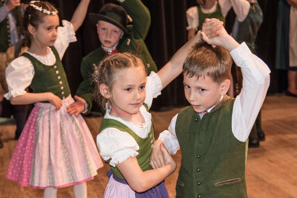 Zwei Kinder tanzen in traditionellen Trachten. Im Hintergrund sind weitere Kinder, die beim Tanz zuschauen. | © Narzissenfest/Herbert Sambs