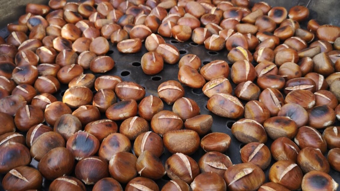 Röstende Kastanien in einer großen Pfanne. Die Kastanien sind gleichmäßig gebräunt und bereit zum Verzehr. | © P. Stossier