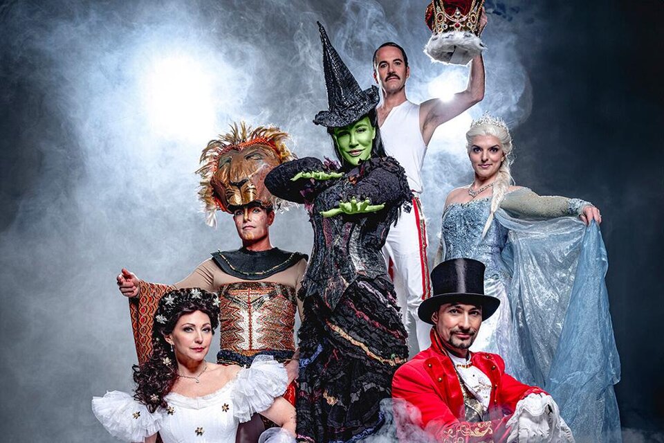 Eine Gruppe von Schauspielern in bunten Kostümen aus verschiedenen Märchenfiguren. Sie posieren dramatisch vor einem rauchigen Hintergrund. | ©  Pura Vida Theater und Musical GmbH