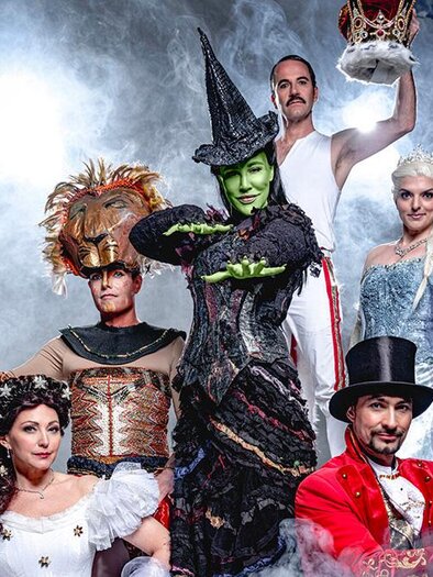 A group of actors in colorful costumes representing various fairy tale characters. They pose dramatically against a smoky background. | ©  Pura Vida Theater und Musical GmbH