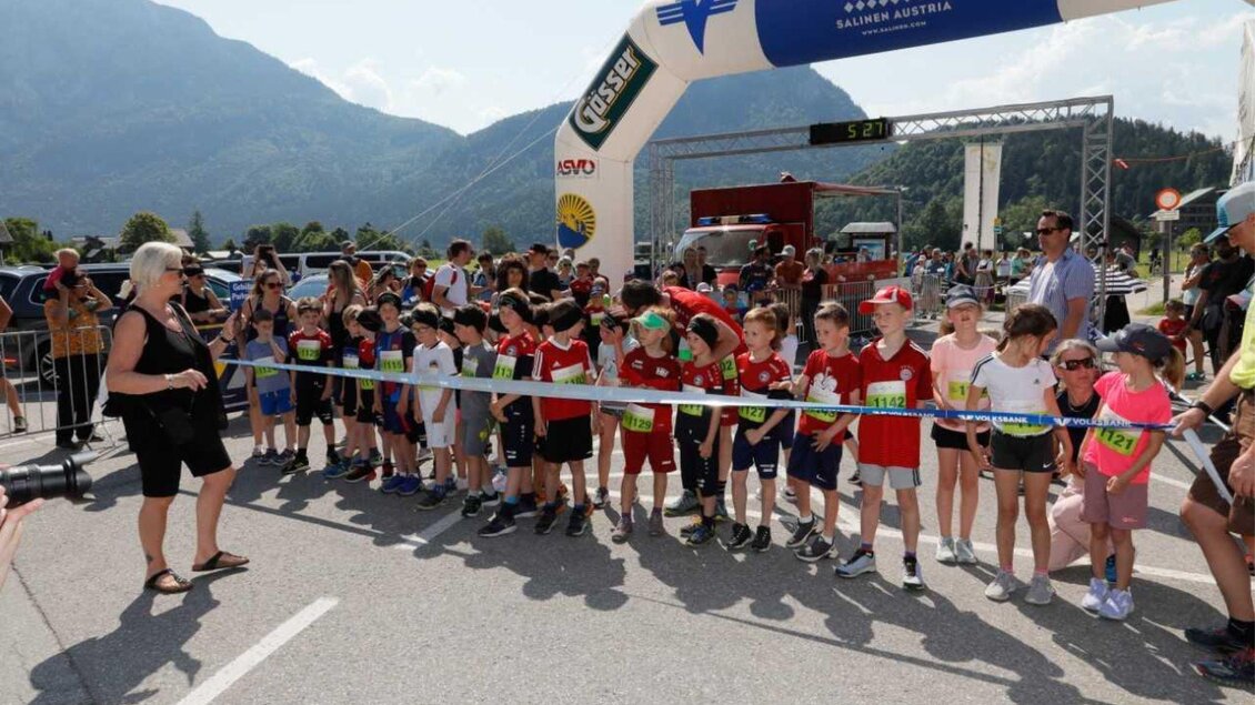 Eine Gruppe von Kindern steht an der Startlinie eines Rennens. Im Hintergrund sind Berge und eine Kulisse mit Zuschauern zu sehen. | © Kainzinger Erich