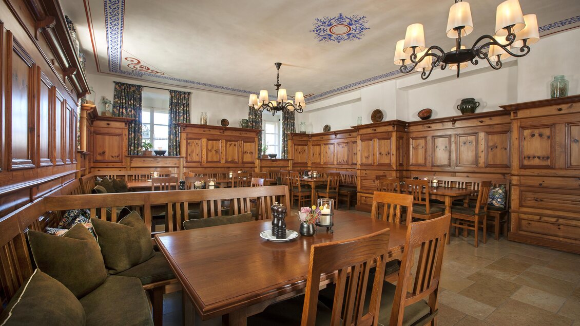 Ein gemütlicher Restaurantbereich mit Holzinterieur und stilvollen Lampen. Der Raum ist hell und einladend, mit mehreren Tischen und Stühlen. | © Tauroa GmbH