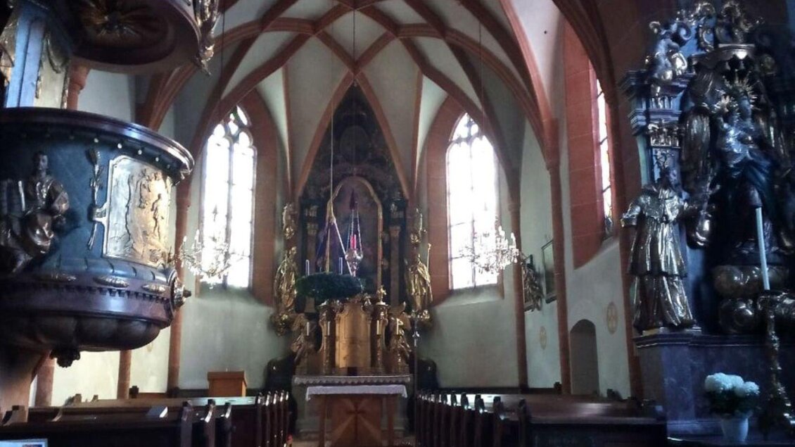 Ein schöner Kircheninnenraum mit hohen, gotischen Fenstern und detaillierten Altären. Die warme Beleuchtung schafft eine ruhige Atmosphäre. | © TVB Ausserland Salzkammergut