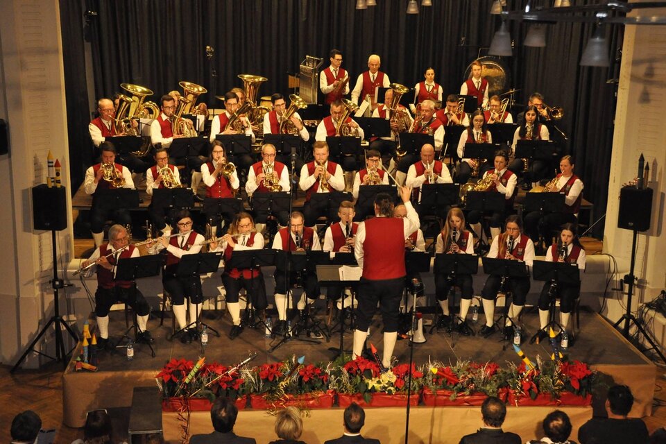 Ein Musikverein spielt auf einer Bühne. Die Musiker tragen traditionelle Kleidung und sind in froher Stimmung. | © GTK Mureck