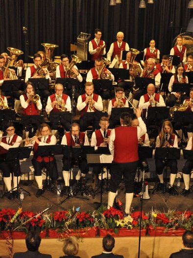 A music club plays on a stage. The musicians wear traditional clothing and are in a cheerful mood. | © GTK Mureck