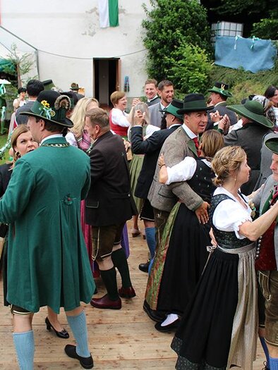 A festive dance event outdoors with people in traditional clothing. The atmosphere is lively and cheerful, surrounded by floats and decorations. | © Stadtgemeinde Leoben