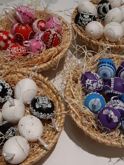 Colorful Easter eggs in straw baskets, artistically decorated with various patterns. The eggs are in the colors white, black, red, pink, blue, and purple. | © Barbara Kozel
