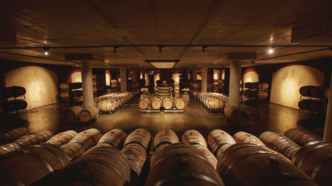Ein Weinlager mit vielen Holzfässern und sanfter Beleuchtung. Die Atmosphäre ist ruhig und einladend. | © Karl Schrotter