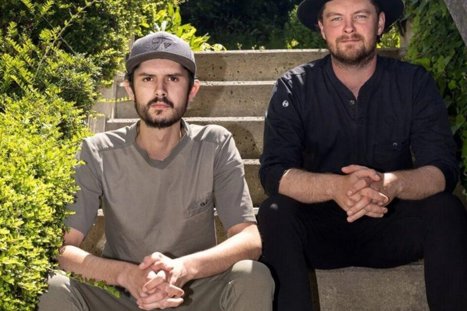 Zwei Männer sitzen auf einer Treppe umgeben von Pflanzen. Sie wirken entspannt und lächeln in die Kamera. | © (c)-kirchgasser-photograph