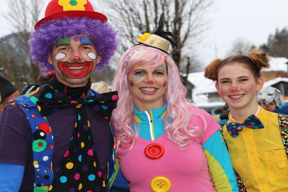 Drei fröhliche Personen in bunten Kostümen stehen zusammen. Sie tragen Clownschminke und lächeln in die Kamera. | © TVB Ausseerland Salzkammergut/Siegfried Zink