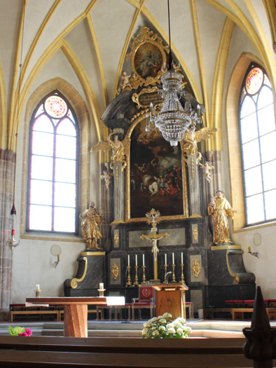 Eine historische Kirche mit hohen Gewölbedecken und bunten Fenstern. Der Altarbereich ist kunstvoll gestaltet und mit Statuen und Kronleuchtern dekoriert. | © TVB Ausseerland Salzkammergut/Lechner Viola
